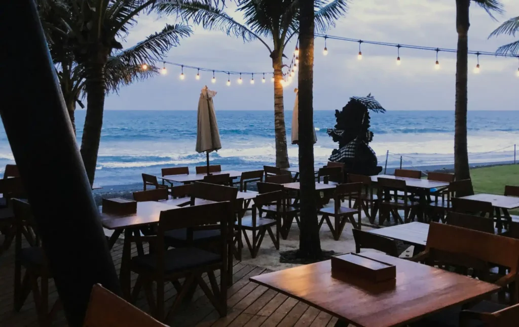 Travelers relaxing at a beach café during sunset