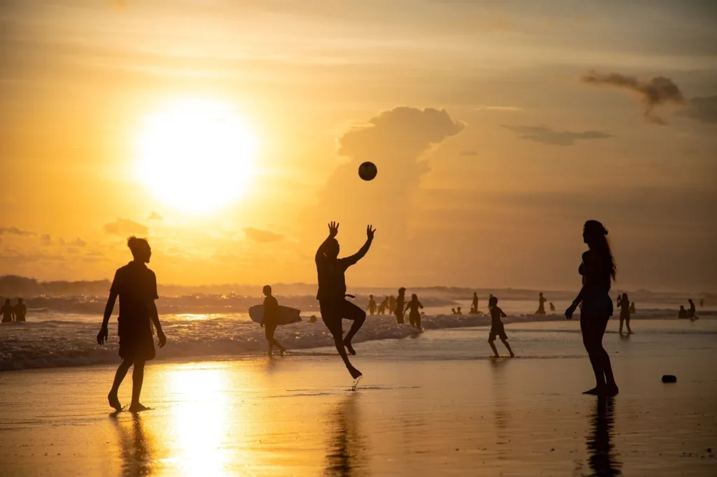 Families and visitors enjoying beach games during sunset at Kite Beach Dubai
