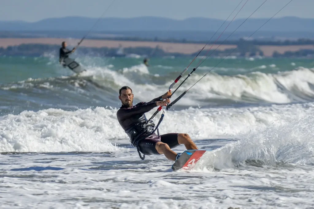  Kitesurfer riding waves at Kite Beach Dubai during windy beach conditions
