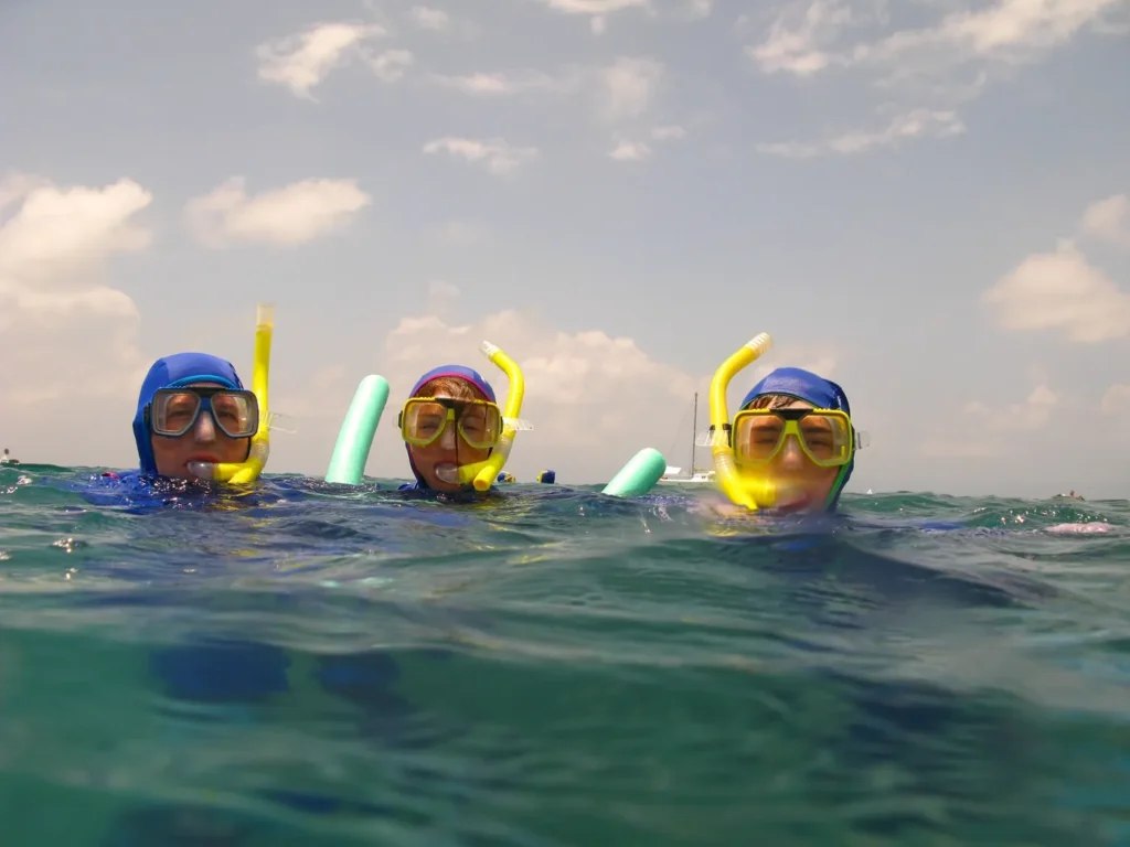 Travelers snorkeling in clear water during Koh Kood snorkeling season.