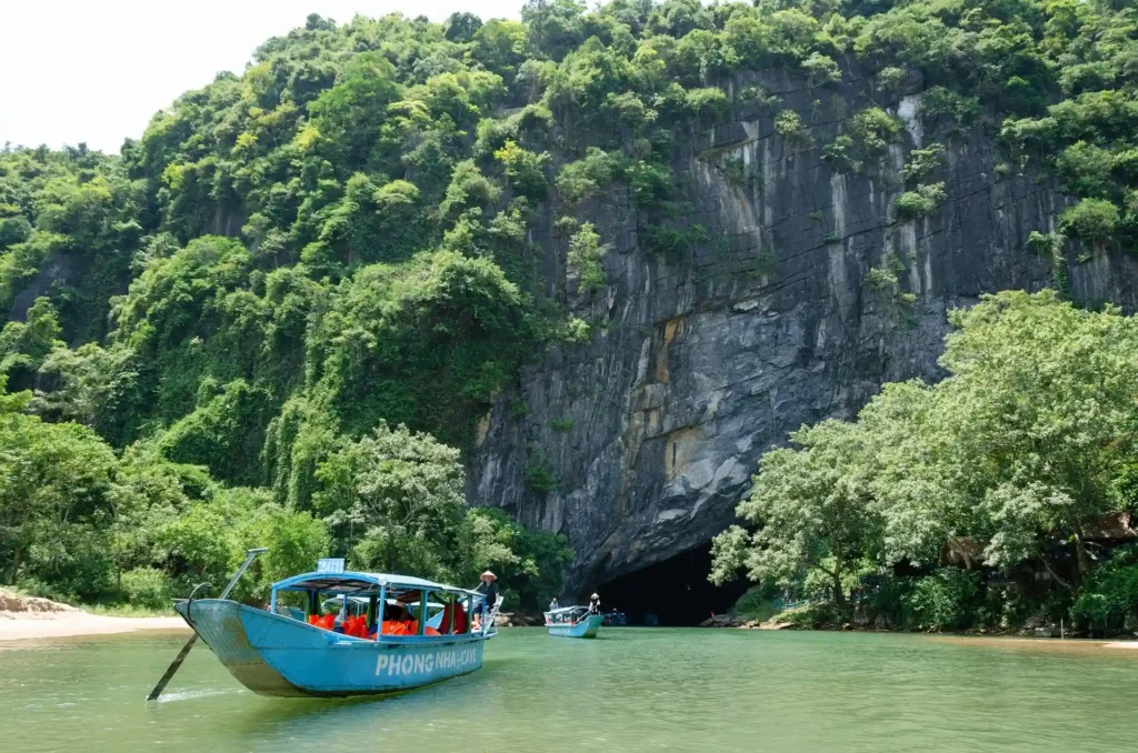 Small boat near limestone cliffs representing island boat transfers to Pulau Kapas