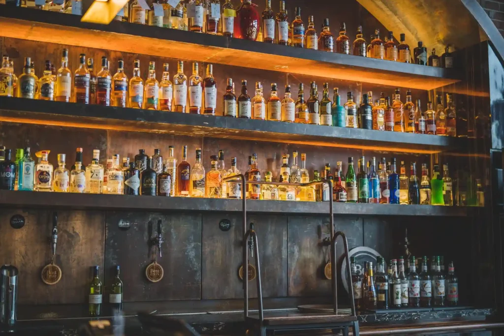 helves filled with liquor bottles inside a stylish Port Barton beach bar at night