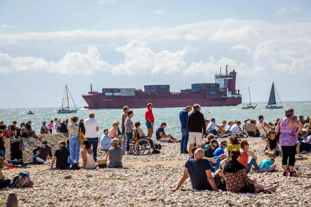 Crowds relaxing and socializing on a beach in Port Barton during daytime