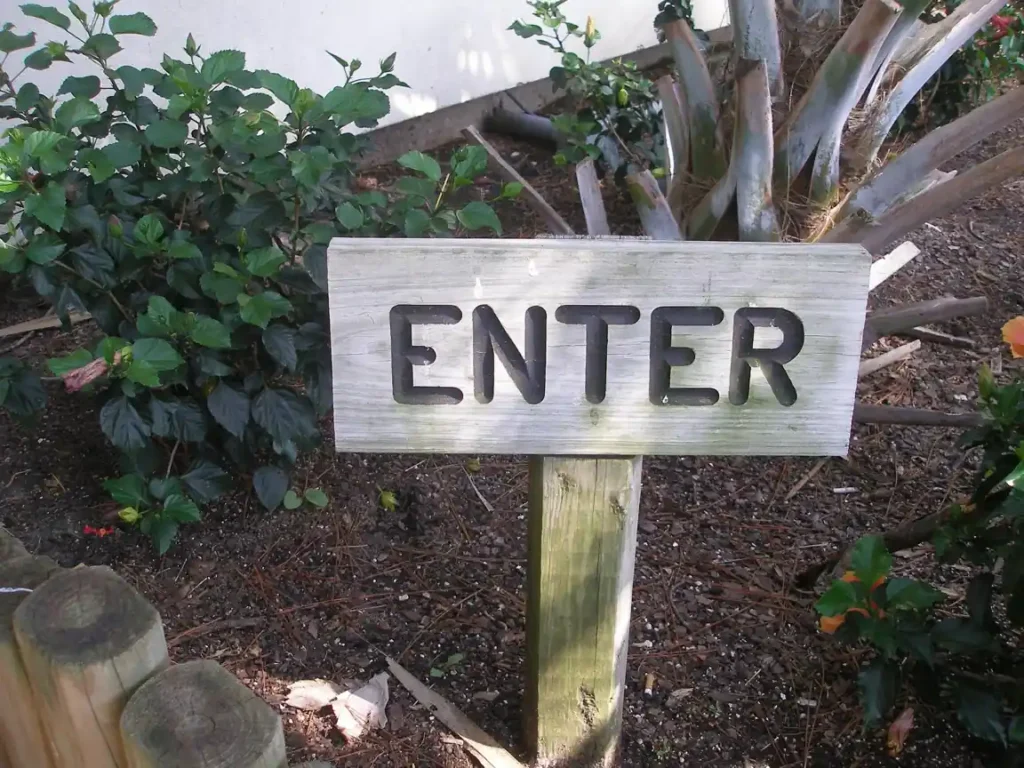 Wooden enter sign symbolizing visitor access and marine park entry regulations.