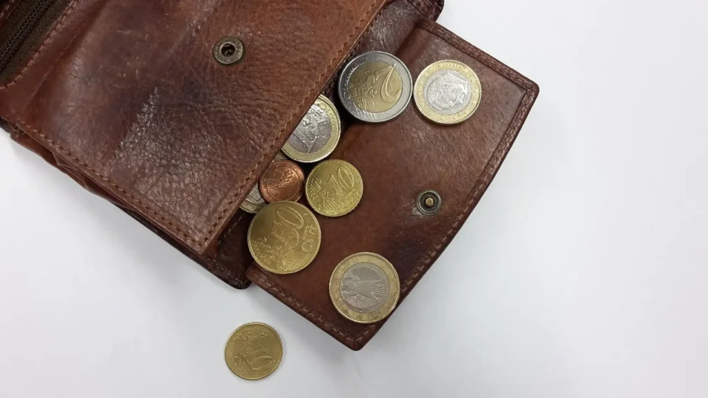 Wallet with cash coins representing Selong Belanak entrance fees and cash-only payments