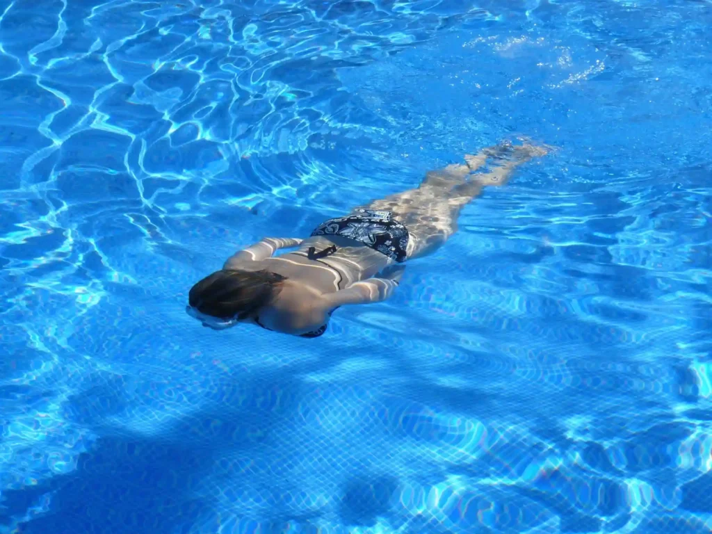 Swimmer in clear blue water illustrating swimming safety at Selong Belanak Beach