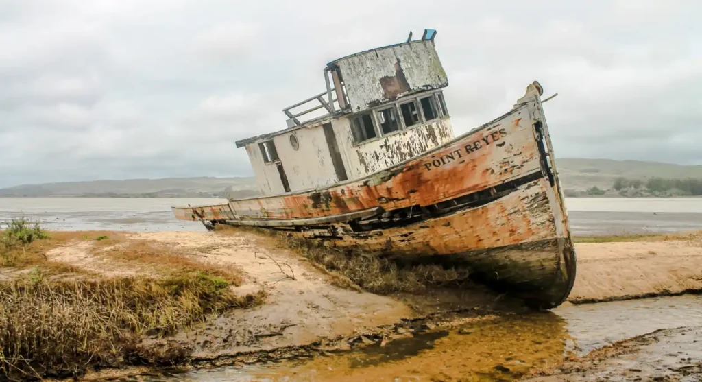 Rust-colored shipwreck on Nyang Nyang Beach during golden hour