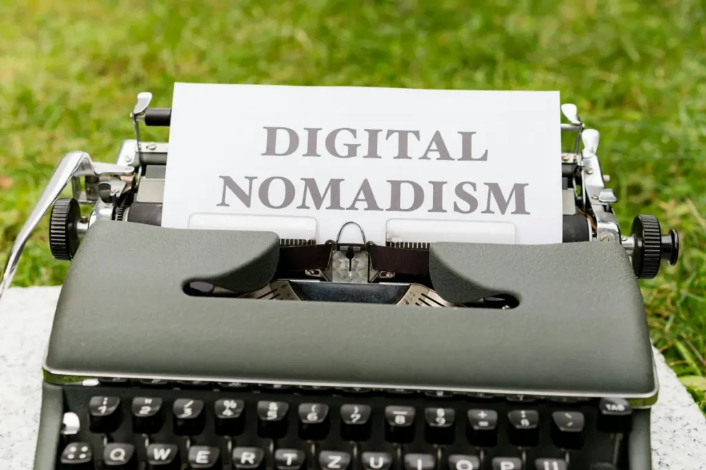 Digital nomad concept shown on a typewriter with the words “Digital Nomadism” on paper outdoors