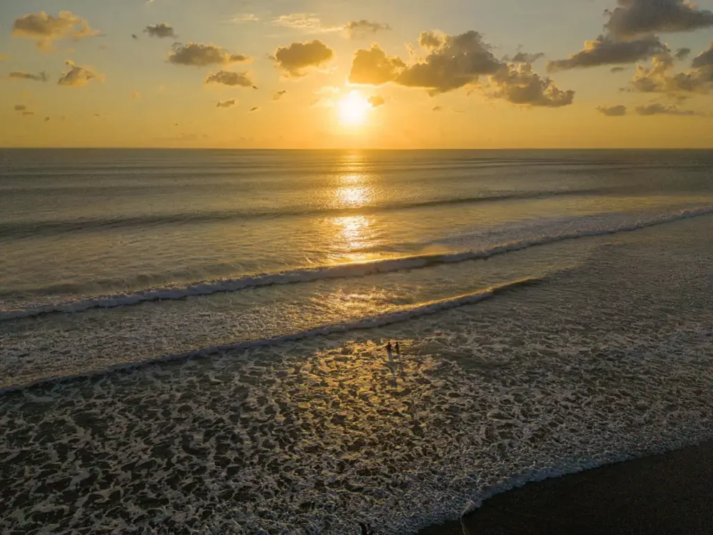 Aerial sunrise view over Nyang Nyang Beach and rolling ocean waves.