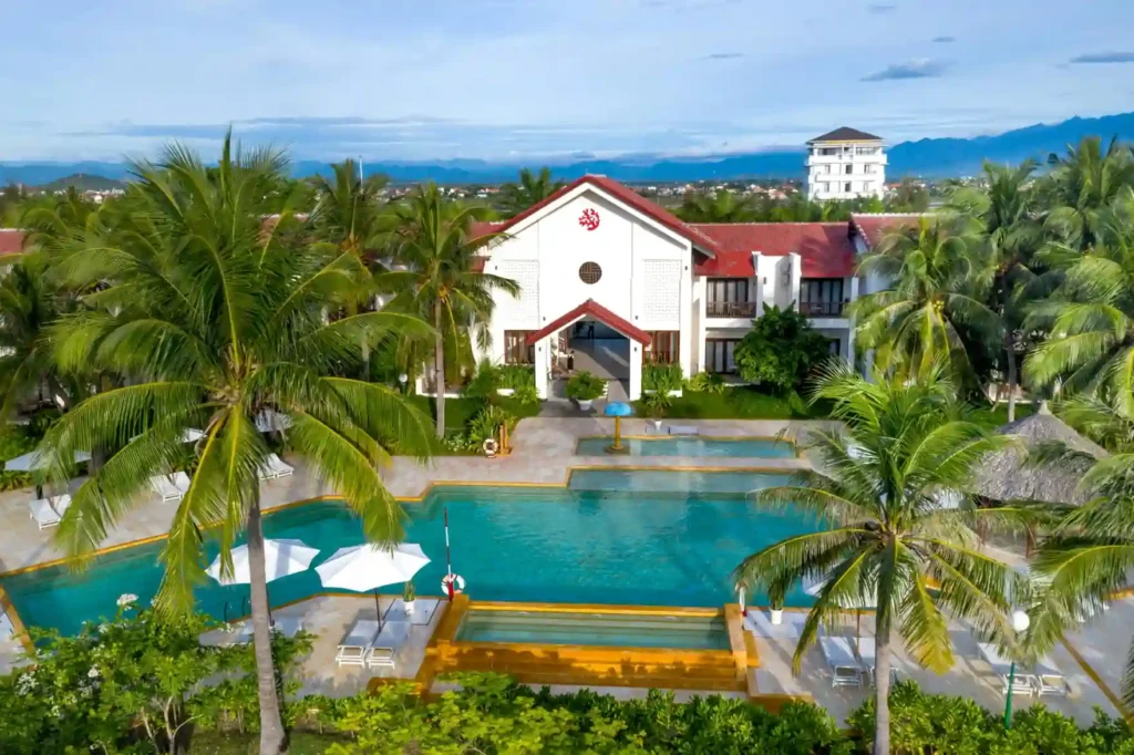 Aerial view of a luxury tropical resort near Agonda Beach with palm trees, a large swimming pool, and peaceful beachfront-style accommodation in South Goa