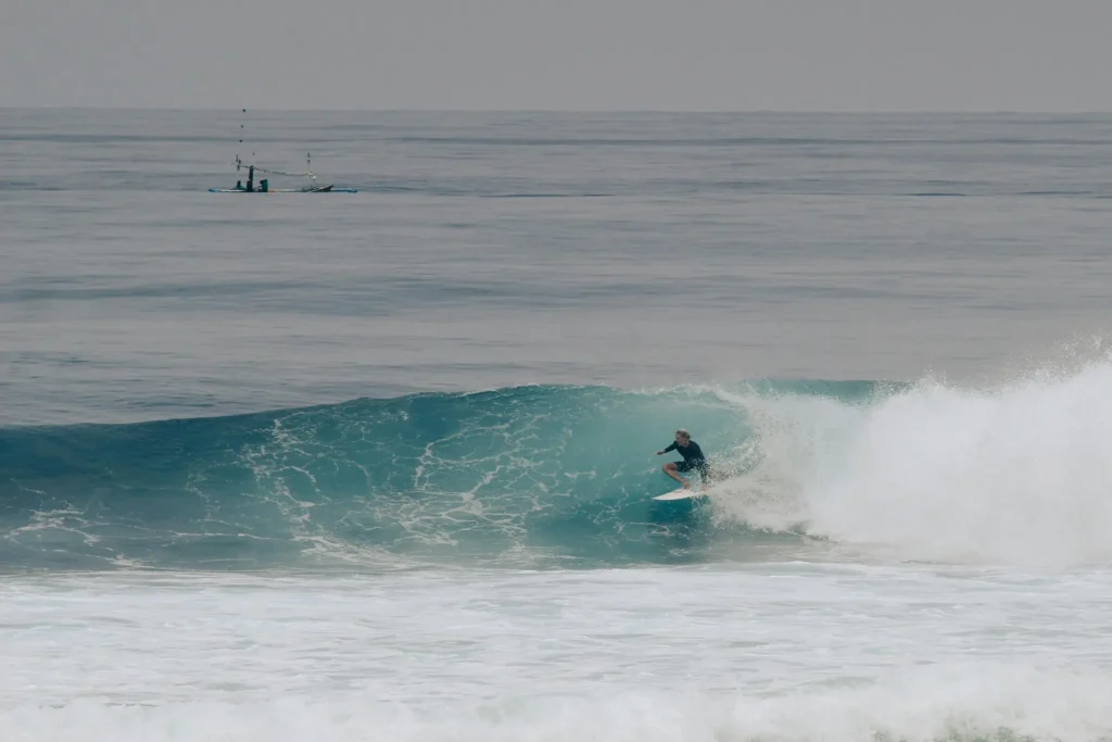 Surfer riding waves at Balangan Beach in Bali
