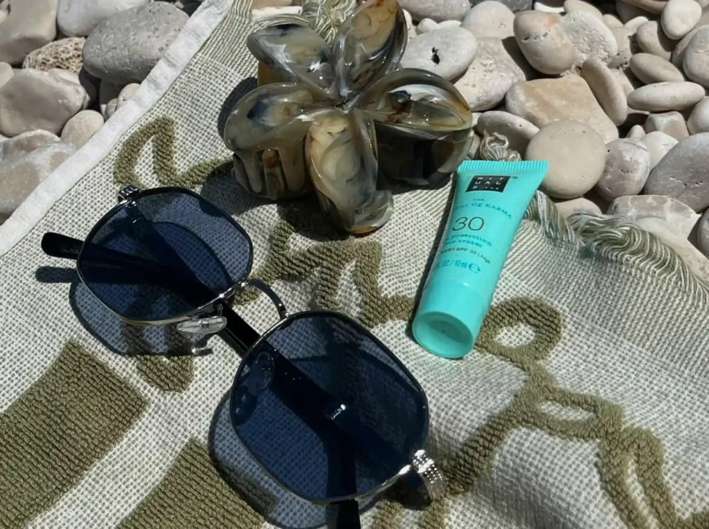 Beach travel essentials including sunscreen and sunglasses for a Bali beach trip