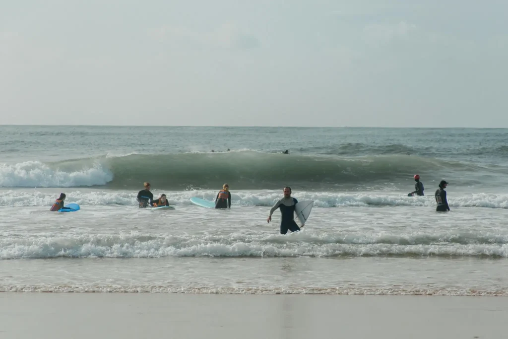 Beginner surfers learning in small waves at tropical beach