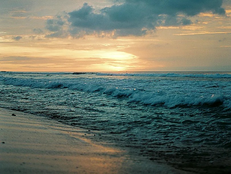 Golden hour waves rolling onto the shoreline at Nyang Nyang Beach during sunset