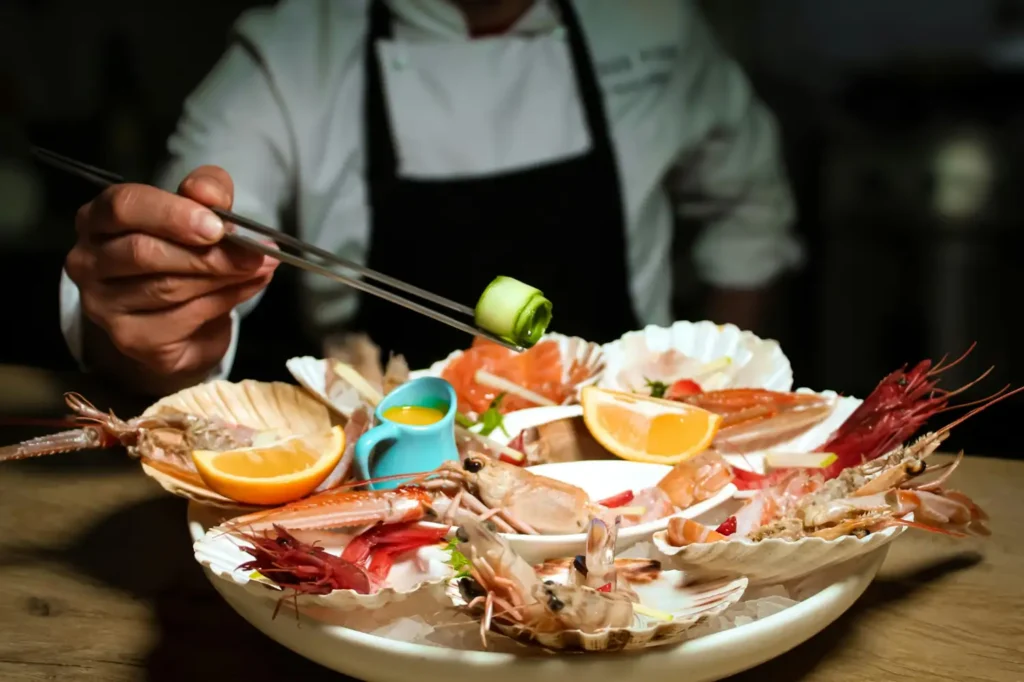 Fresh seafood platter with prawns, shellfish, and citrus served at a local coastal restaurant in Chabahar, Iran.