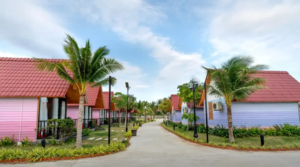 Colorful tropical resort bungalows in Con Dao with palm trees, landscaped paths, and peaceful island surroundings.