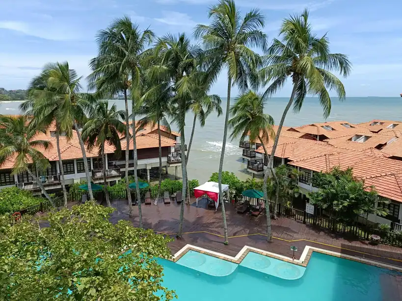 Luxury beachfront resort in Con Dao with palm trees, ocean-view villas, and swimming pool overlooking the sea.