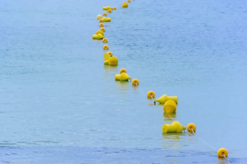 Yellow floating boundary buoys lined across calm blue water near a protected marine zone in Con Dao, Vietnam