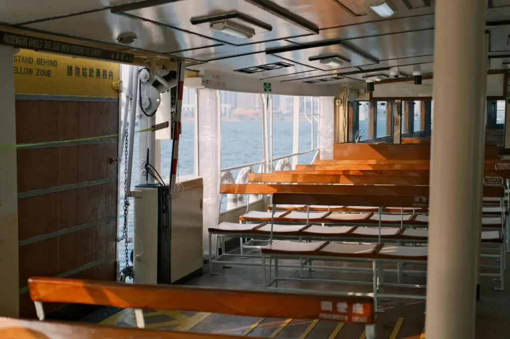 Wooden bench seating inside a passenger ferry during a scenic Koh Kood boat journey in Thailand.