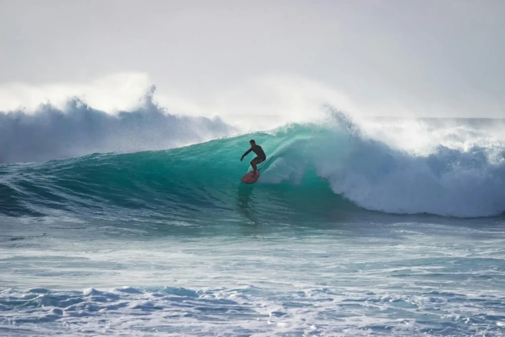 Surfer riding a powerful ocean wave at Hiriketiya Beach