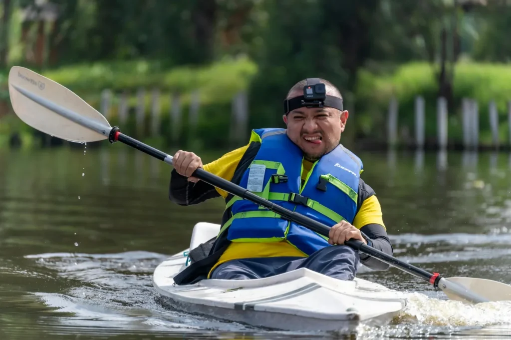 Traveller kayaking through calm mangrove waters in Koh Kood while wearing a life jacket and action camera during an outdoor adventure activity.