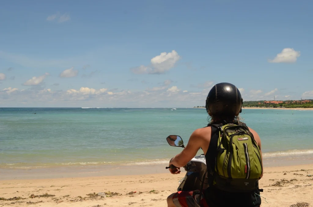Traveler riding a scooter near Nyang Nyang Beach in Bali with ocean views along the Uluwatu