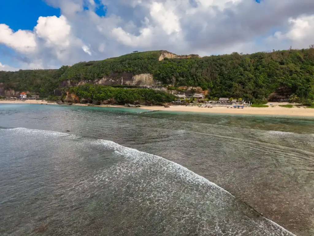 Wide cliffside view of a hidden Bali beach with turquoise ocean water