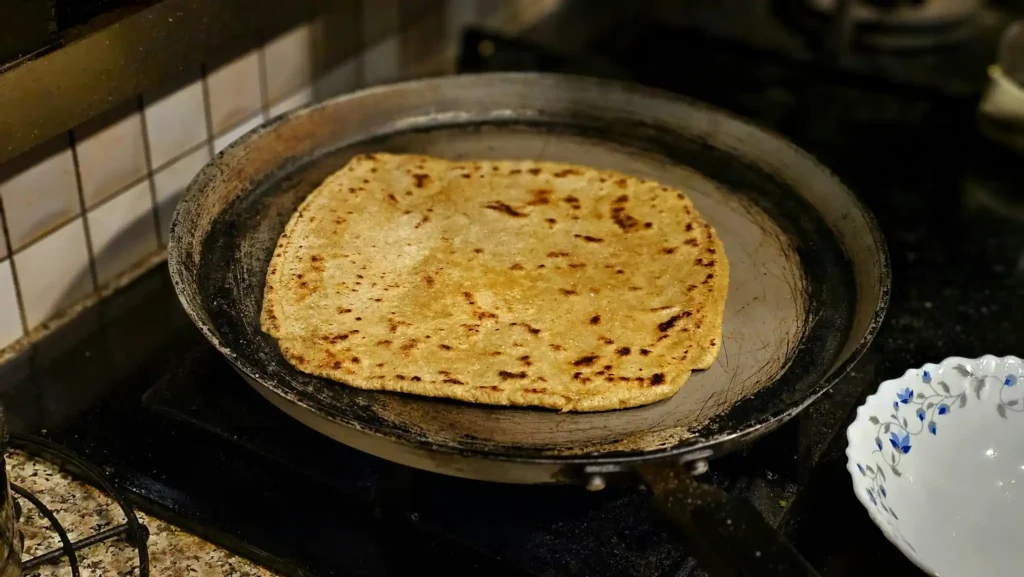 Sri Lankan roti cooking on a pan in a local kitchen