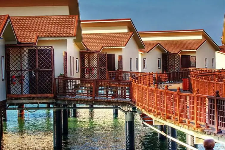 Overwater villas connected by wooden walkways at Toranj Marine Hotel on Kish Island, Iran.