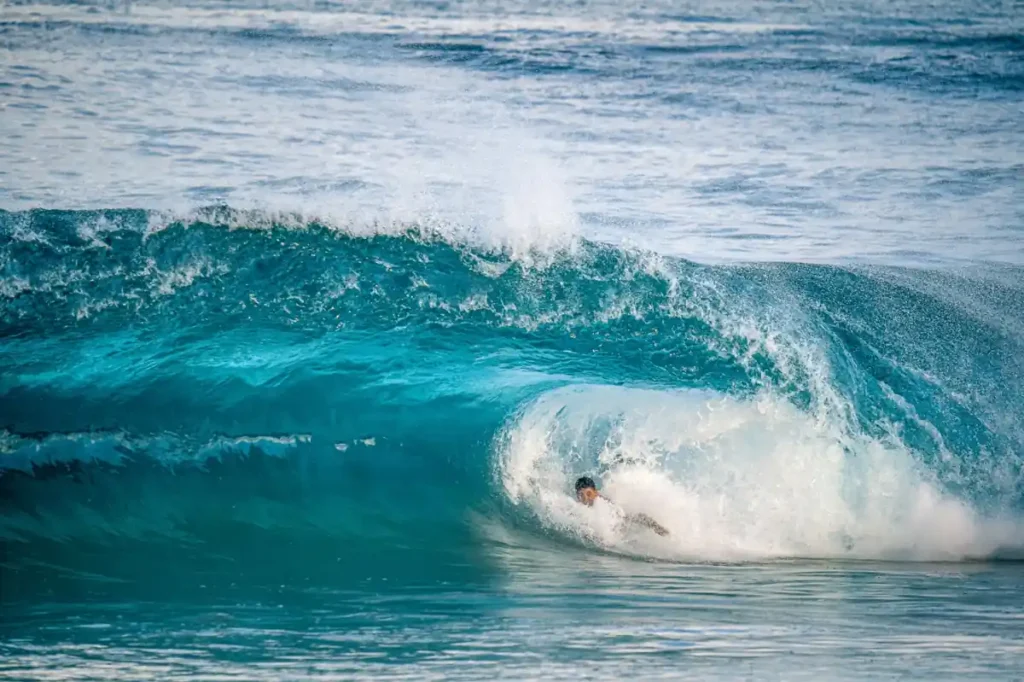 Surfer riding a powerful wave at Balangan Beach.
