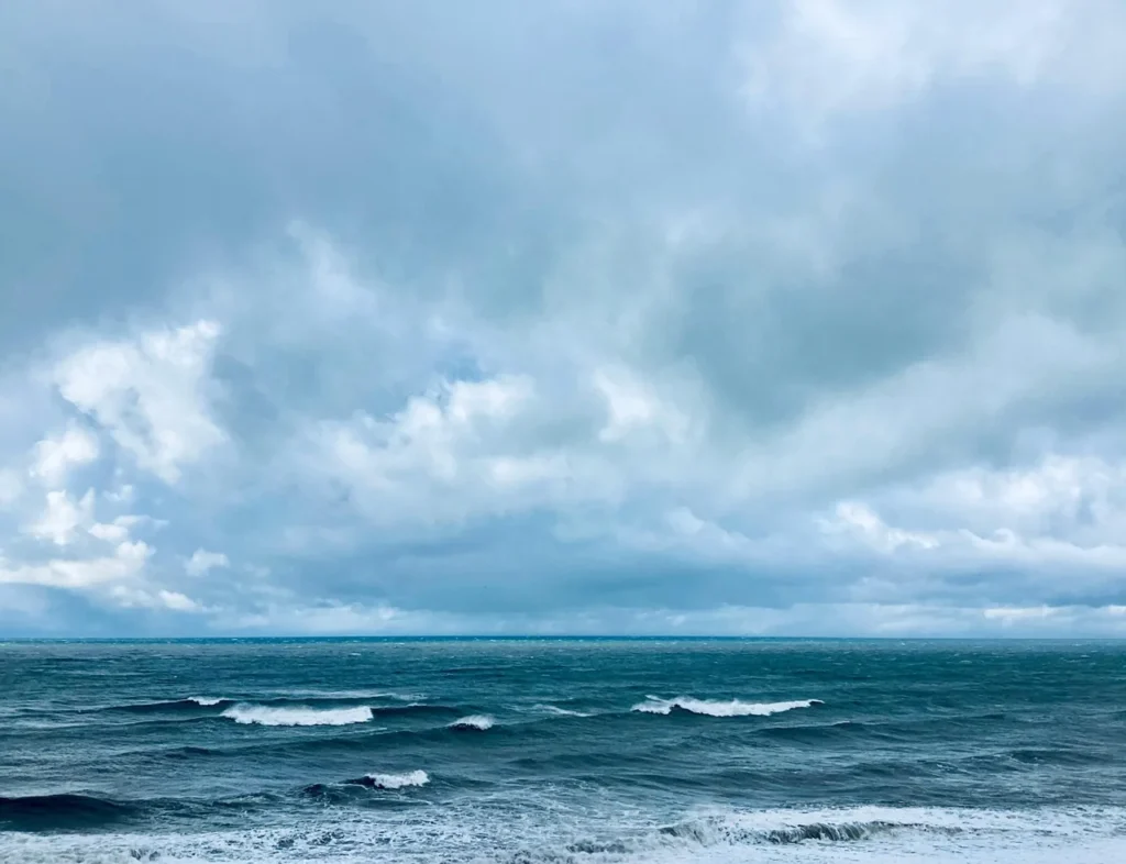 Rough ocean waves under cloudy weather, showing unsafe swimming conditions near Goyambokka Beach.