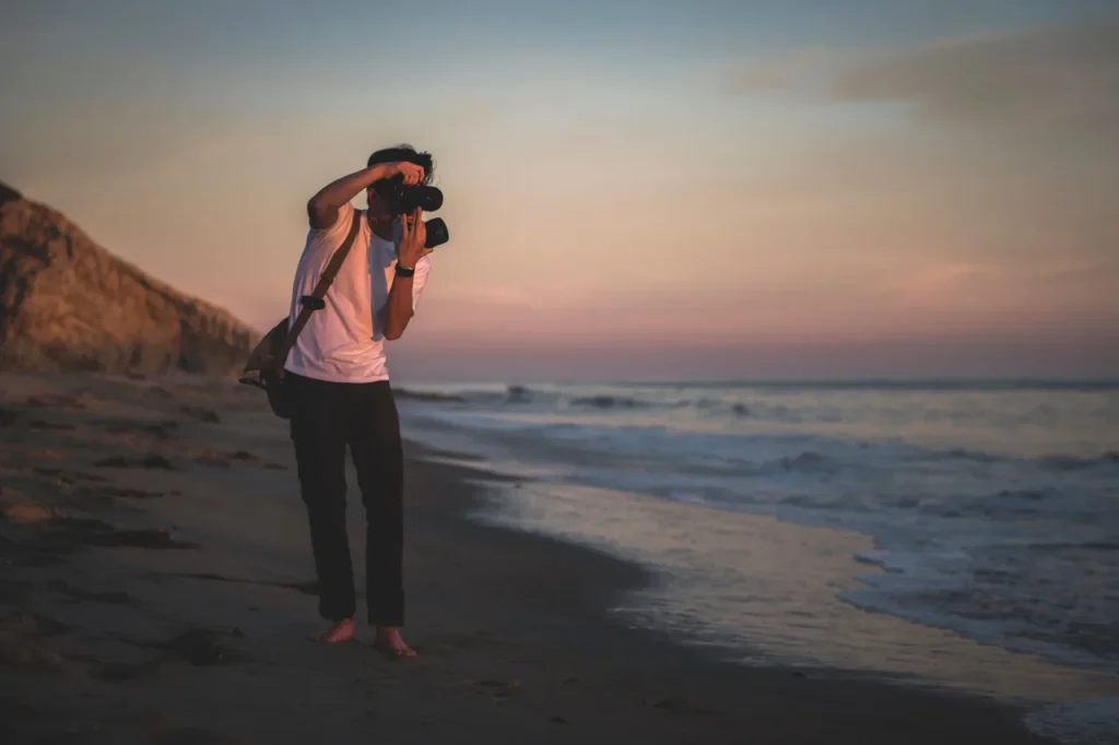 Photographer taking pictures on a quiet beach at sunset near Goyambokka Beach. 