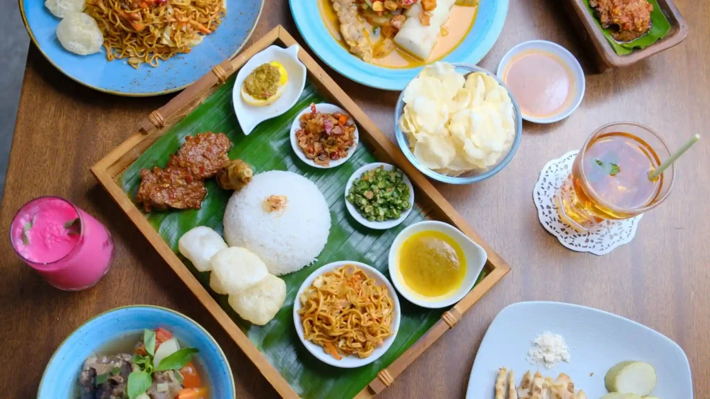 Traditional Indonesian meal with rice, noodles, and side dishes. 