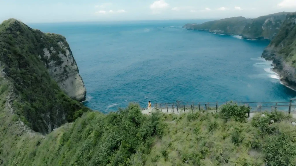 View of Kelingking Beach cliffs and blue ocean from the viewpoint.