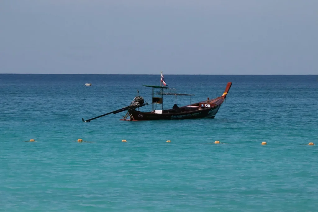 Longtail boat floating on turquoise sea near Koh Lipe with calm water and open blue horizon.