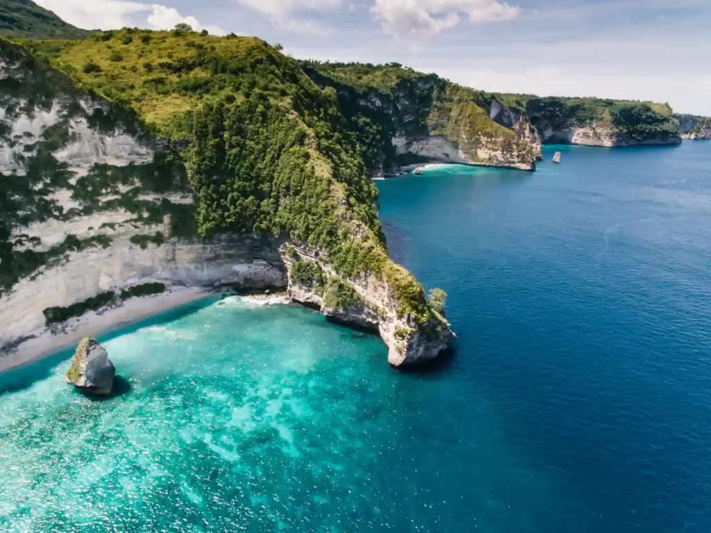 Aerial view of Nusa Penida coastal cliffs and turquoise bay. 