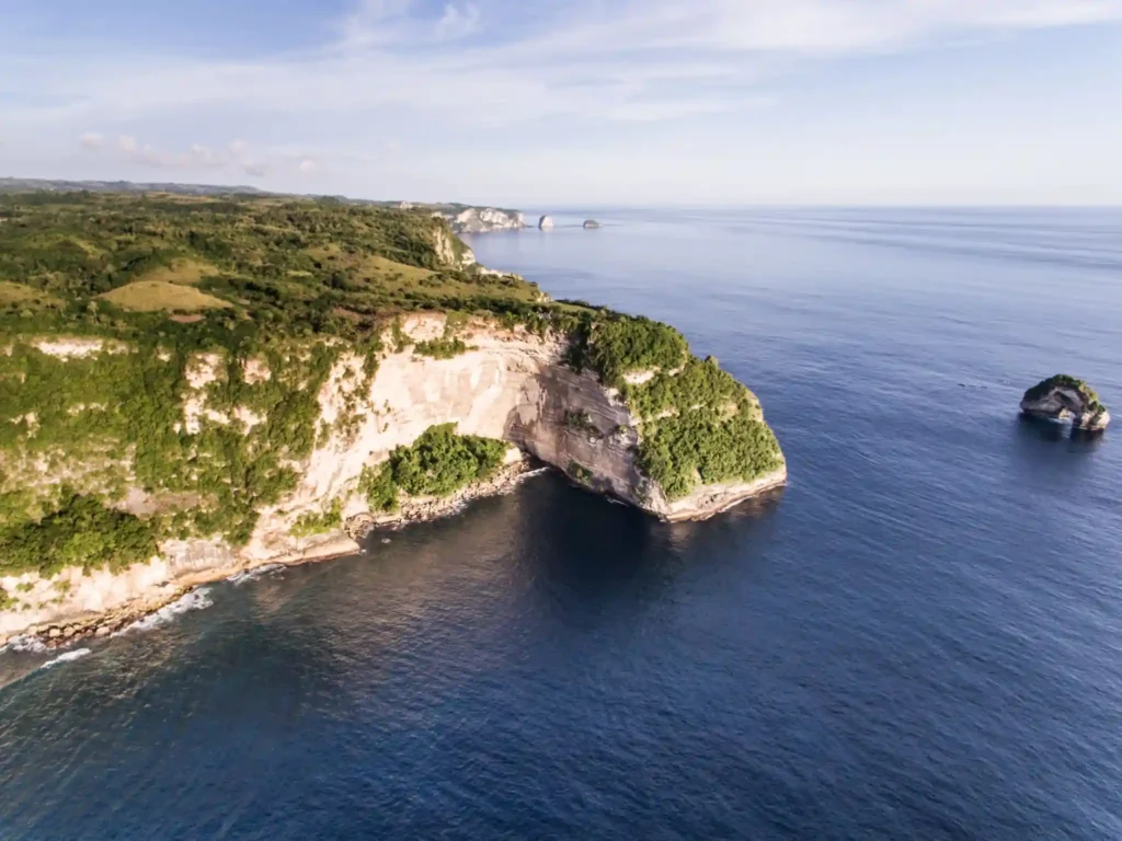 Aerial view of Nusa Penida's rugged coastline and blue ocean.