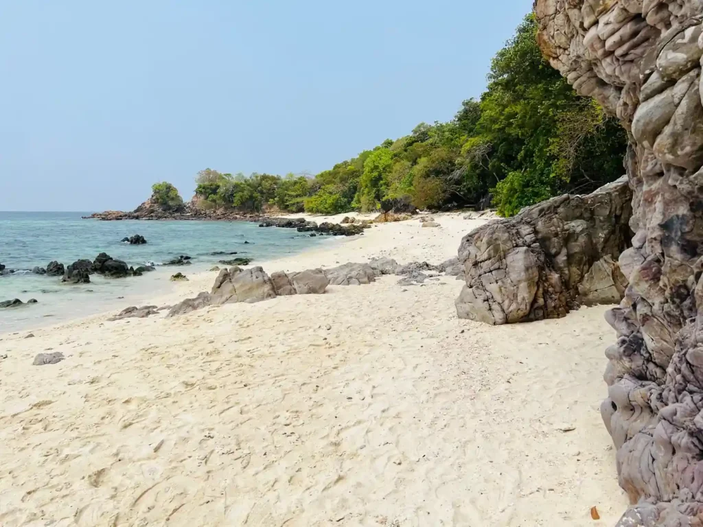 Rocky tropical beach with white sand. 
